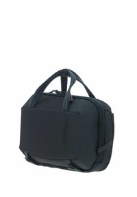 Sac Thule compact gris foncé à coque souple, doté de doubles poignées et d'une fermeture éclair, conçu pour transporter de petits objets ou des appareils électroniques.