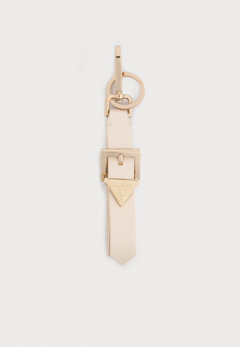Keychain accessory with a light beige leather strap, gold-tone hardware, featuring a triangular gold emblem with "GUESS" branding.
