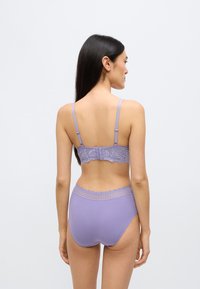 Levandulová sada spodního prádla zahrnující podprsenku s krajkovými zády a nastavitelnými ramínky a k ní ladící kalhotky s vysokým pasem a krajkovým lemem v pase.