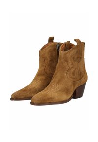 Botas de ante marrón hasta el tobillo con puntera afilada, cremallera lateral, costuras decorativas y tacón apilado. El acabado texturizado realza los detalles del diseño.