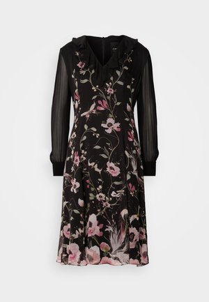 Vestido preto floral com decote em V franzido, mangas longas transparentes e barra fluida. Apresenta padrões florais rosa e brancos com detalhes em verde.