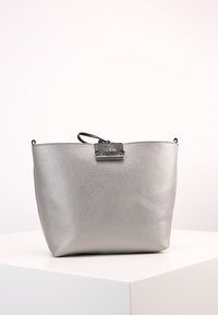 Bolso de cuero texturizado plateado con un asa superior, que presenta una placa del logo negro de Guess y un diseño minimalista.