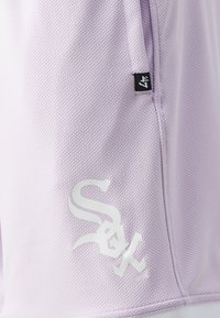 Shorts en tissu texturé violet avec un logo blanc imprimé et une étiquette de marque sur la couture latérale.