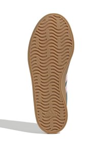 Skosula med tanfärgad gummitred med vågiga spår och rektangulära grepp, Adidas-logotyp prägla nära hälen, sidan av skon synlig.