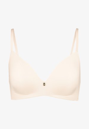 Beige bra with a smooth, stretchy fabric, plunge neckline, and adjustable straps. Notable gold hardware accent at the center.