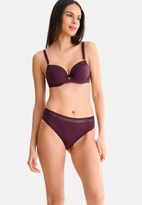 Bordeaux lingerieset met een gevormde beha met kantdetails en bijpassende high-waisted slipjes, beide van een gladde stof en met veilige bandjes.