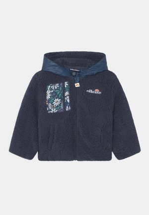 Jaqueta azul-marinho com fecho éclair, textura felpuda, capuz suave e bolso no peito com padrão floral. Apresenta o logótipo na parte frontal direita.