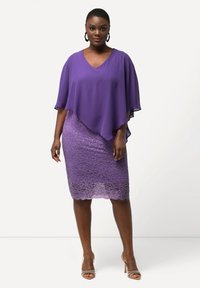 Haut en chiffon violet avec un superposé en V, associé à une jupe en dentelle ajustée d'une teinte de violet plus claire, avec un ourlet festonné.