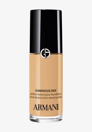 Flacon de fond de teint Armani Luminous Silk, maquillage liquide beige avec bouchon noir et logo argenté, étiqueté "fond de teint éclat naturel parfait."