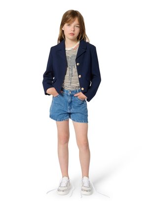 Blazer marine avec boutons dorés, chemise rayée et short en denim. Chaussures : baskets argentées avec lacets blancs. Design simple.
