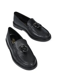 Para czarnych, teksturowanych skórzanych loafersów z okrągłym metalowym i koralikowym zdobieniem na cholewce, płaskimi gumowymi podeszwami i markowymi wkładkami.