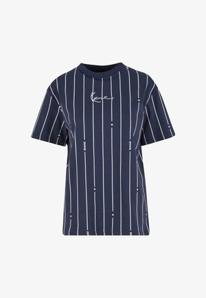 Tumedat särk, mis on valmistatud puuvillast, valgete vertikaalsete triipudega ja trükitud tekstiga. Lühikeste varrukatega ja ümmarguse kaelusega.