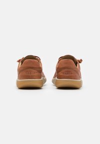 Braune Lederschuhe mit texturiertem Finish, runder Form, beige Gummisohle und minimalistischem Design. Mit KEEN-Logo an der Ferse.