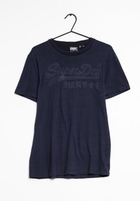 Námořnická modrá bavlněná tričko s krátkým rukávem, s texturovaným potiskem loga v tmavším odstínu na přední straně a kulatým výstřihem.