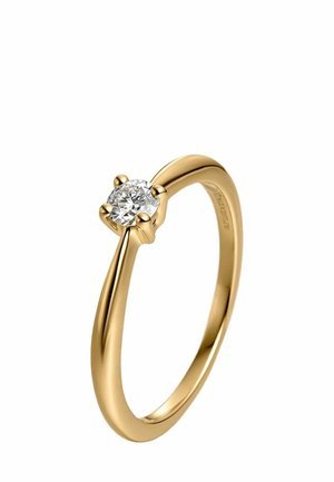 Anillo de compromiso de oro con un solo diamante redondo sostenido por cuatro garras sobre una banda lisa y pulida.