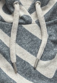 Grå och krämrandig huvtröja med dragsnodd, med metallspetsar på dragsnoddarna och ett mjukt, texturerat stickat tyg.