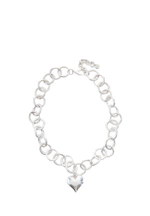 Bracelet chaîne en argent avec de gros maillons ronds et un pendentif en cristal clair en forme de cœur suspendu au centre.