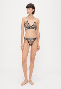 Bralet leopard print și thong asortat, cu bretele subțiri și o bandă elastică neagră cu logo-ul "justcavalli", realizate dintr-un material moale.
