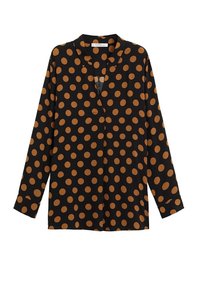 Musta pitkähihainen paita avonaisella kauluksella, jossa on isoja oransseja pilkkuja. Valmistettu sileästä kankaasta rentoa istuvuutta varten.