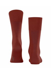 Calze di lana rosse con polsino a costine, design senza cuciture e tallone e punta rinforzati. Presenta il nome del marchio "FALKE" stampato sul lato.