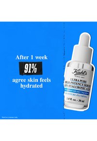 Flacon compte-gouttes en verre transparent avec un capuchon compte-gouttes blanc. L'étiquette présente un texte noir et bleu, indiquant "Sérum Ultra Pur Haute Potence Kiehl's."