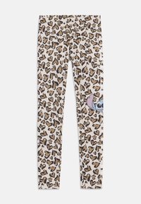 Beige alapszínű leggings barna és fekete szív alakú leopárdmintával, és egy mesefigura kukucskálóan a szélén.