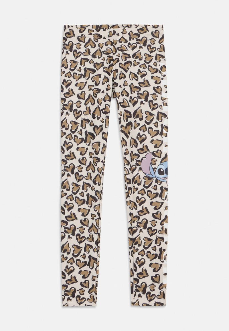 Beige alapszínű leggings barna és fekete szív alakú leopárdmintával, és egy mesefigura kukucskálóan a szélén.