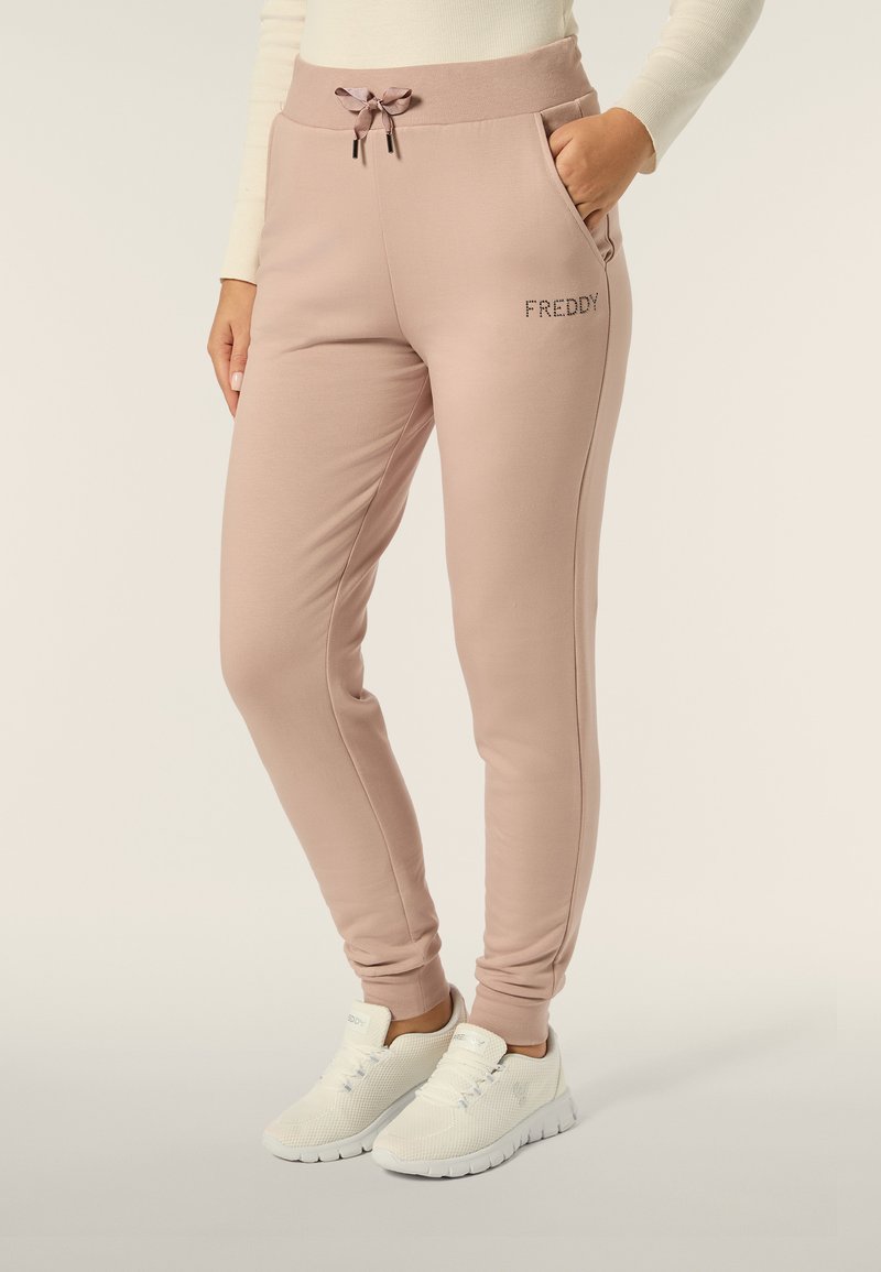 Pantaloni da jogger rosa chiaro con vita elastica, chiusura con cordoncino, tasche laterali e logo "FREDDY" ricamato sulla coscia.