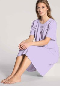 Camicia da notte lavanda con maniche corte, vestibilità ampia e dettagli arricciati sul busto. Tessuto morbido e design lungo fino alla caviglia.