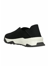 Scarpa nera slip-on con tomaia in tessuto texturizzato, suola bianca a contrasto e suola esterna in gomma resistente, caratterizzata da un design minimale.