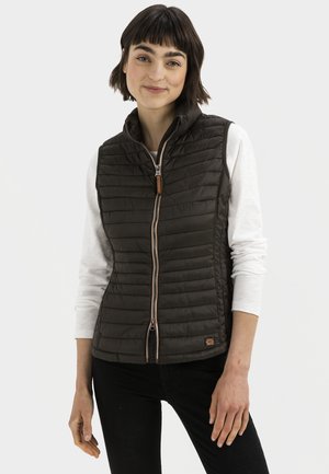 Dunkelolivgrüner ärmelloser Weste mit gestepptem Muster, Reißverschluss vorne und braunem Leder-Zugband, getragen über einem weißen Langarmshirt.