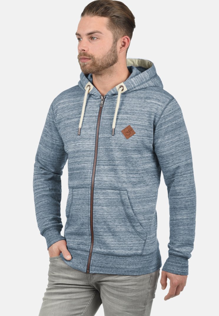 Sudadera con cremallera en azul jaspeado, hecha de un tejido suave, con un bolsillo frontal, capucha con cordón y un parche de logo de cuero en el pecho.