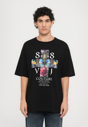Black oversized t-shirt featuring a vibrant graphic design with a butterfly, rose, and text "88 VJ COUTURE LIMITED EDITION FALL/WINTER 25-26."