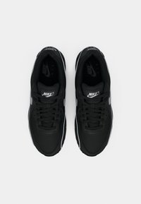 Sneakers neri Nike con tomaia in tessuto liscio, linguetta imbottita e dettagli bianchi, suola in gomma e design con lacci.