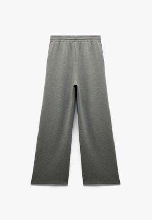 Pantalones de chándal grises con un diseño de pierna ancha, cinturilla elástica y textura suave. Presenta un estilo sencillo sin bolsillos ni adornos.