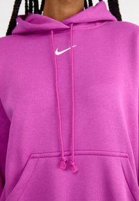 Purple hooded sweatshirt made of soft fabric, featuring a kangaroo pocket, drawstrings, and a small white logo on the chest.