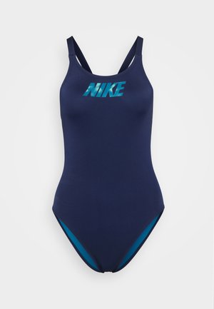 Jūras zila viengabala peldkostīms ar plānām siksnām, uz kura priekšpuses ir Nike logo tirkīza krāsā un kontrastējoši tirkīza akcenti sānos.