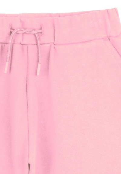 Un pantalon de survêtement rose en tissu doux, doté d'une taille élastique avec cordon de serrage et de poches latérales, conçu pour le confort et la praticité.