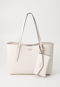 Bílá texturová kožená taška Guess s dvěma ramenními popruhy a odnímatelnou odpovídající peněženkou zavěšenou na jednom popruhu.