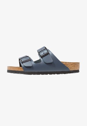 Blue synthetic slide sandals with two adjustable straps and buckles. Cork footbed with a textured surface, resting on a black rubber sole.