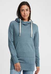 Sudadera con capucha azul hecha de un tejido suave, con un bolsillo frontal, detalles de cordón y un corte ligeramente más largo para una mayor cobertura.