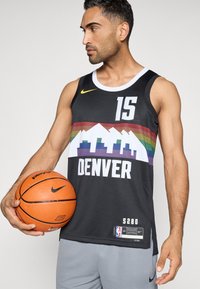 Musta koripallopaita, jossa on valkoisella, punaisella, vihreällä ja sinisellä "DENVER" ja vuoristografiikka. Sisältää Nike-logon ja kokolapun.