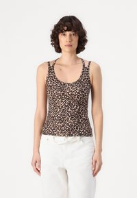 Leopard-print tank top in soft fabric. Features thin straps and a scoop neckline. Paired with white high-waisted pants.
