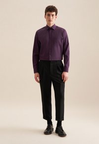 Paarse lange mouwen shirt met een button-down kraag, gecombineerd met zwarte op maat gemaakte broeken; vlakke voorkant, verkorte lengte, en zwarte schoenen.