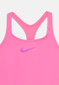 Débardeur de sport rose avec un design dos nageur. Il comporte un petit logo Nike violet à l'avant et des coutures plates pour plus de confort.