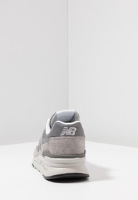 Szare sneakersy z siateczkowej i zamszowej cholewki, białymi akcentami, amortyzowaną podeszwą oraz fakturowanym wzorem z małym logo na pięcie.