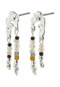 Orecchini in argento con una forma organica, caratterizzati da perline colorate di diverse dimensioni e trame, appesi a un supporto in argento texture.