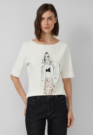 T-shirt blanc à manches courtes en tissu doux, arborant un dessin minimaliste en ligne noire sur le devant avec un motif de jupe florale.