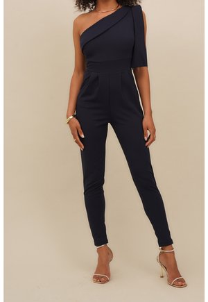 Navy-Ein-Schulter-Jumpsuit aus dehnbarem Material mit enganliegenden Beinen, Falten an der Taille und einem strukturierten Schulterdetail. Schlichtes Design.