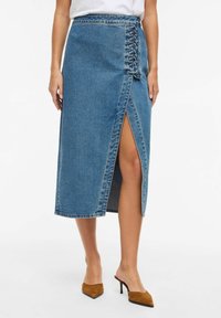 Denim-Midirock in Hellblau mit einem Frontschlitz und seitlichen Schnürdetails. Verfügt über einen rohen Saum und ein klassisches Fünf-Taschen-Design.